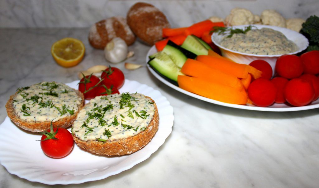 Fresh and spicy veggie dip with vegetables and creamy breakfast spread on bread