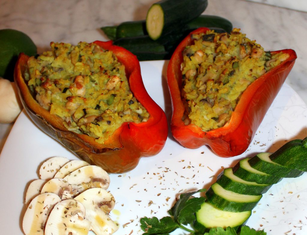 Two stuffed red bell pepper halves with zucchini and mushrooms