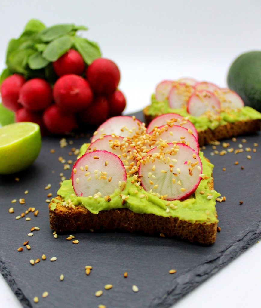Avocado toast with fresh radishes in close-up