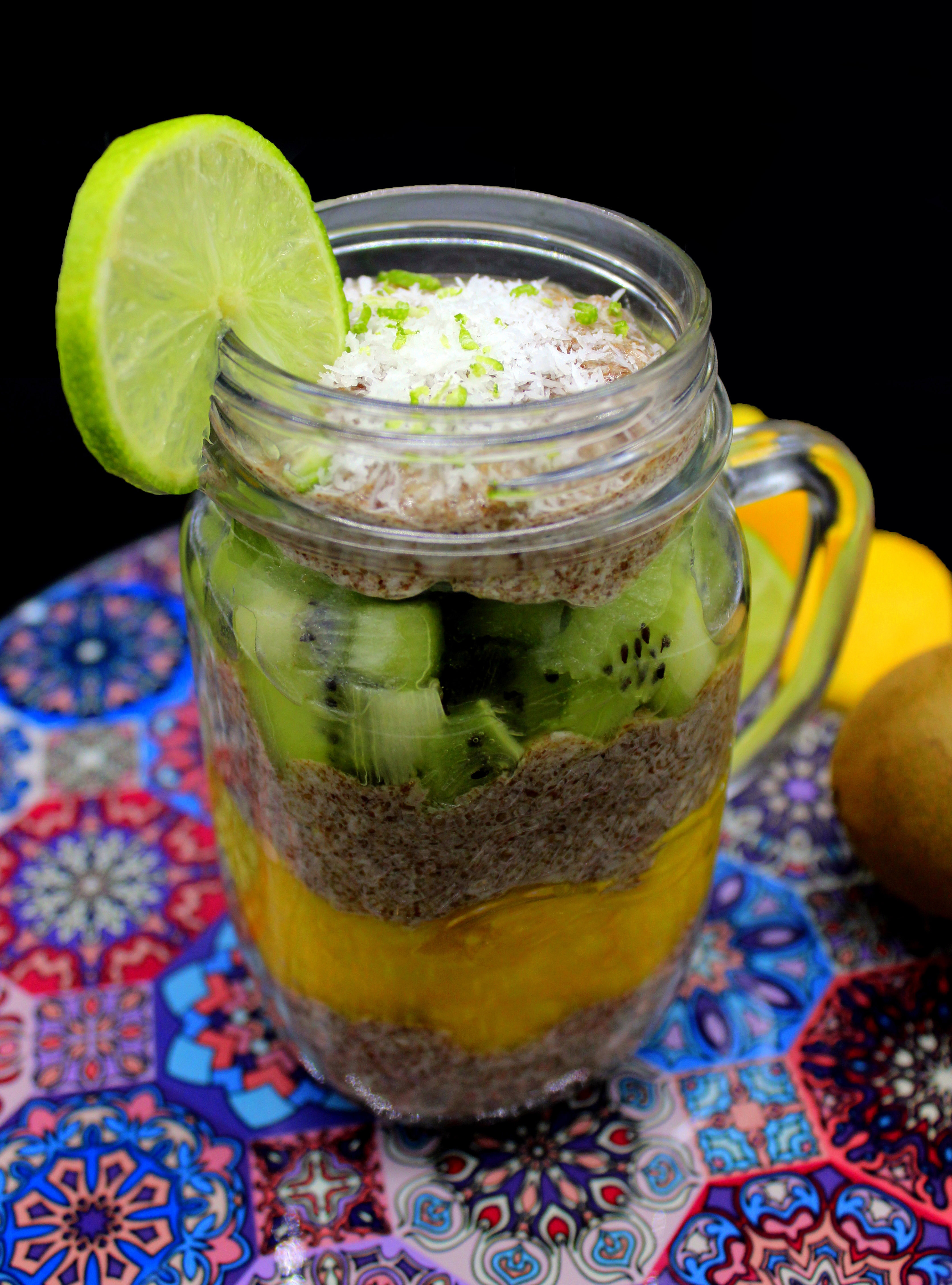Vegan flaxseed pudding with kiwi and mango in a mason jar decorated with a slice of lime